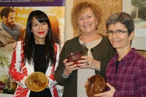 Dr. Anna Jo, owner of Cornerstone Family Dentistry, Kim Dolan, Executive Director of YWCA Peterboorugh Haliburton and Joelle Favreau, Manager of Nourish, holding beautiful handmade bowls